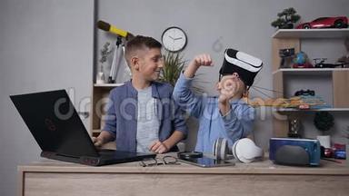 满意的青少年朋友一起使用电脑和增强现实眼镜玩电子游戏
